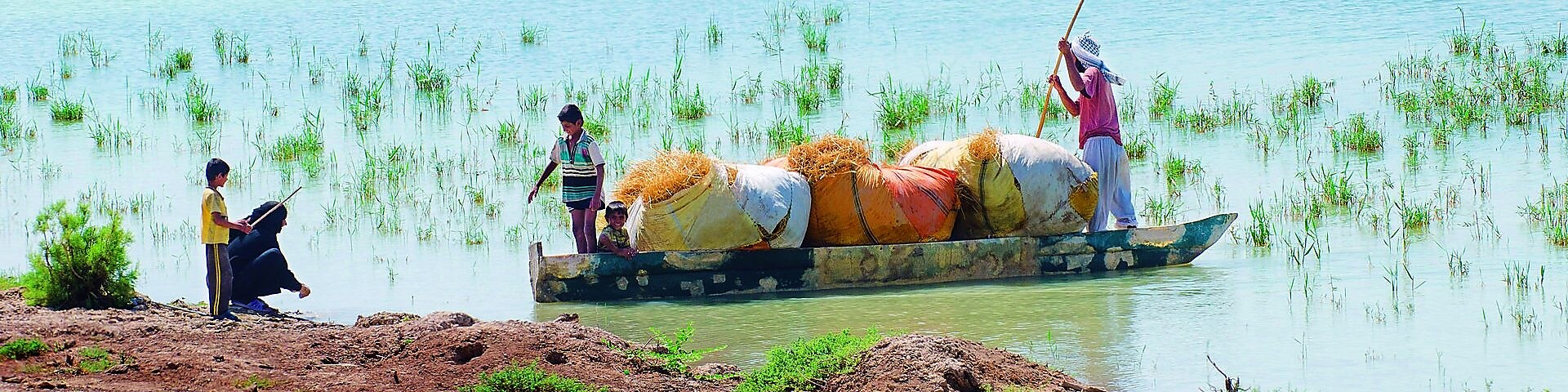 Local people cross the flooded Hawizeh Marshes, near the Majnoon project in Iraq